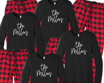 May include: A set of black long-sleeved shirts with the text "The Millers" in white script. Each shirt is paired with red and black plaid pajama pants.