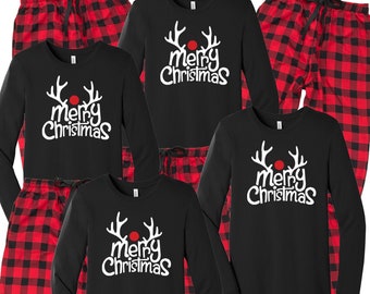 May include: Black long-sleeve shirts and red plaid pajama pants. The shirts have a white graphic of reindeer antlers and the words "Merry Christmas". The pajama pants are red and black buffalo plaid.
