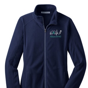 May include: A navy blue fleece jacket with a zipper closure. The jacket has a small embroidered design on the left chest that includes a heart with a paw print inside, a stethoscope, and an EKG line. The text "Allison BVMS" is embroidered below the design.