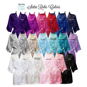 Puede incluir: Una selecci&oacute;n de batas de sat&eacute;n en varios colores, incluyendo morado, orqu&iacute;dea, fucsia, rojo, azul real, azul marino, plateado, champ&aacute;n, azul cielo, aguamarina, azul turquesa, lavanda, blanco, blanco roto, rosa claro, rosa y negro. Las batas est&aacute;n dispuestas en filas, con los colores etiquetados debajo de cada bata.