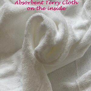 May include: White terry cloth fabric, folded and showing the soft, absorbent texture. The text "Absorbent Terry Cloth on the inside" is visible on the fabric.