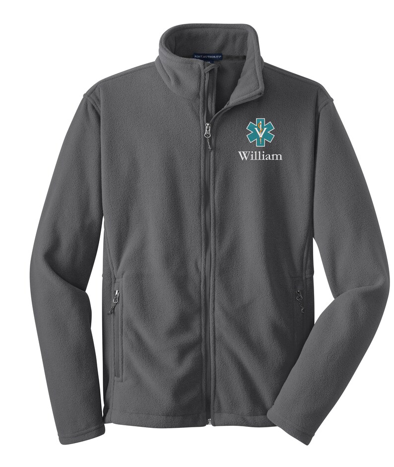 May include: A gray fleece jacket with a zipper closure. The jacket has a  star of life logo and the name "William" embroidered on the left chest.