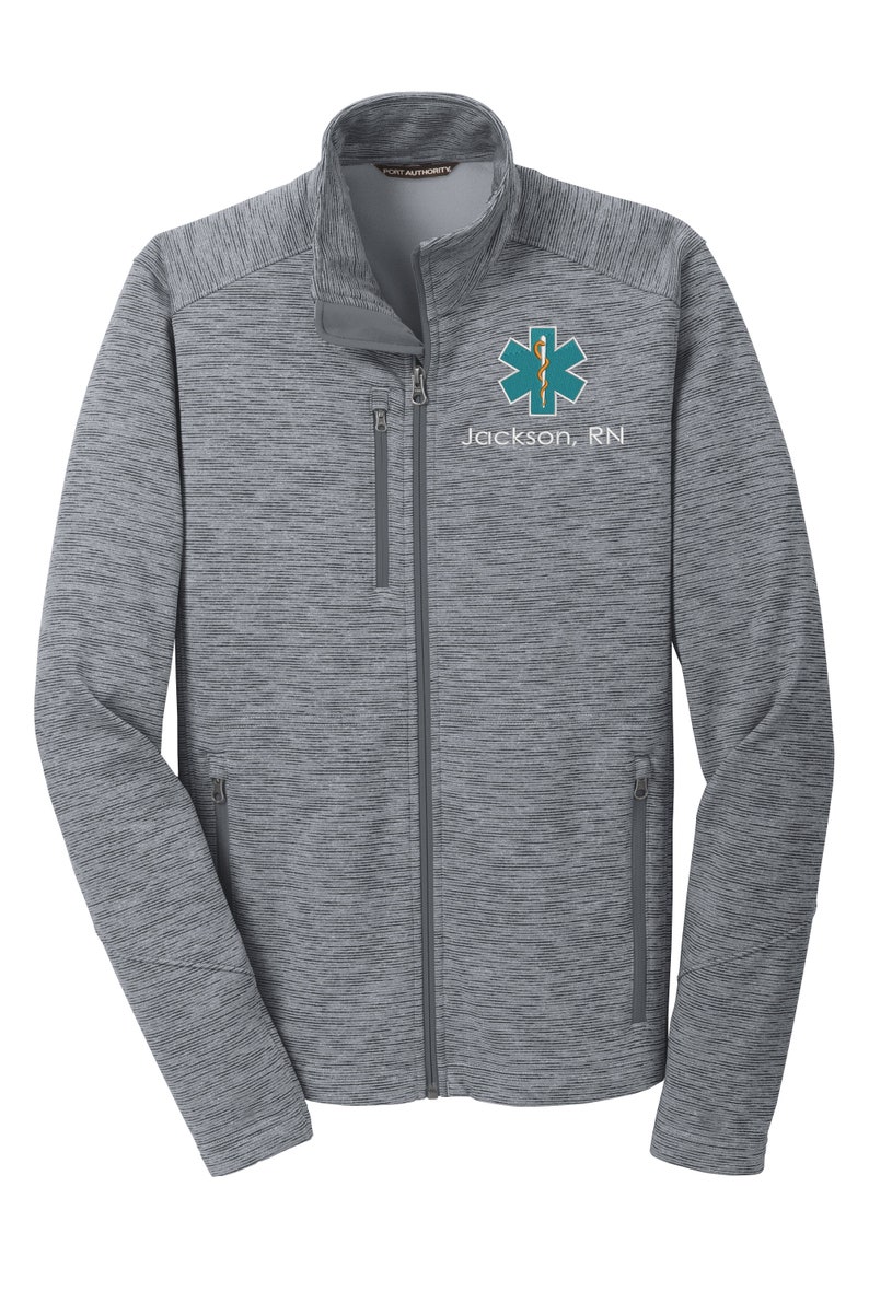 May include: A gray heather zip-up jacket with a teal star of life and the text "Jackson, RN" embroidered on the left chest.