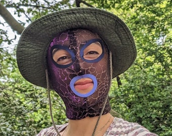 See through mask with shiny purple and gold scale pattern, purple mouth contour and dark blue around the eyes.