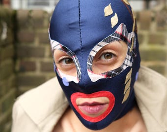 Navy blue fabric mask with beige plaid eye contours, dots, various symbols and red lips.