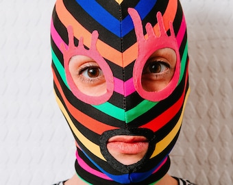 Stripy colorful mask with pink funky contours of the eyes.