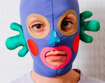 Double-Sided Purple Mask: Colourful details, Green Wavy Volume Sides, Sad Face at the back.