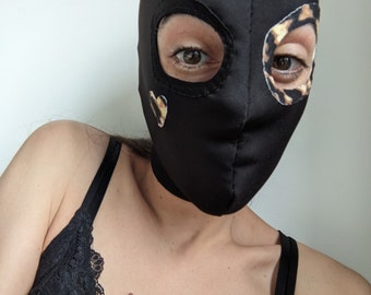 Black assymetric hood with leopard print eye contour and heart detail. Thick stretchy base fabric.