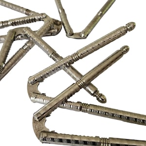 May include: A set of six silver nutcrackers with a decorative, textured design. The nutcrackers are made of metal and have a hinged jaw that opens and closes to crack nuts.