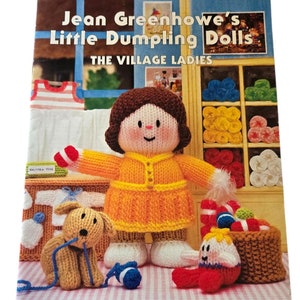 May include: A book titled "Jean Greenhowe's Little Dumpling Dolls: The Village Ladies" featuring a knitted doll, a knitted dog, and a knitted baby. The book cover has a pink and white checkered background and the text "Double Knitting Yarn www.jeangreenhowe.com".