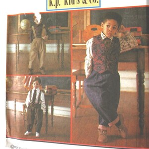 May include: A Simplicity sewing pattern envelope 8567 for k.p. kid's & co. featuring illustrations of children wearing vests, dress shirts, and trousers with suspenders. The white paper packaging displays three distinct outfit combinations.