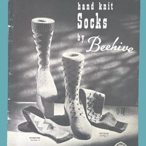 May include: A black and white image of a vintage knitting pattern booklet for hand knit socks by Beehive. The booklet features a photo of three pairs of socks with a geometric pattern. The text on the cover reads "hand knit Socks by Beehive" and "Price 40c Series No. 37".