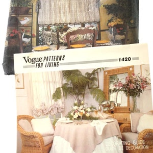 May include: Two vintage Vogue Patterns for Living booklets. The top booklet shows a kitchen scene with a window, curtains, and a table setting. The bottom booklet shows a dining room with a table setting and wicker furniture. The text "Vogue Patterns For Living" is visible.