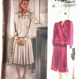 Può includere: Modello di cucito Vogue Patterns con un design di Adele Simpson. Il modello include una camicetta a maniche lunghe con fiocco e una gonna a pieghe. L'immagine mostra anche un disegno dell'outfit in un colore diverso.