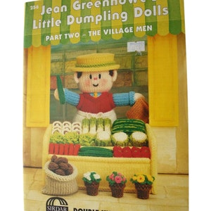 Peut inclure: Une couverture de livre avec un fond jaune et un auvent vert. Le titre est "Jean Greenhowe's Little Dumpling Dolls" et le sous-titre est "Part Two - The Village Men". La couverture présente une poupée tricotée habillée en maraîcher, vendant des légumes et des fleurs.