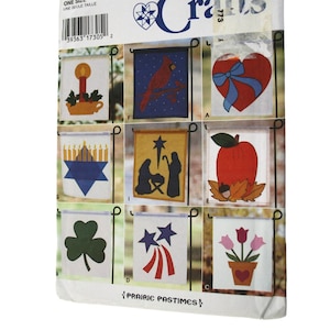 Peut inclure: Un patron Simplicity Crafts pour réaliser 9 drapeaux de jardin différents. Les drapeaux présentent une variété de motifs, notamment un cardinal, un cœur, une menorah, une scène de la nativité, une pomme, un trèfle, des feux d'artifice et des tulipes. Le patron est intitulé "Prairie Pastimes".