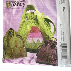 May include: A McCall's Fashion Accessories sewing pattern envelope M4884 featuring illustrations of three drawstring bags in green and purple fabrics with geometric and floral embroidery designs, with the text Sewing with Nancy visible.