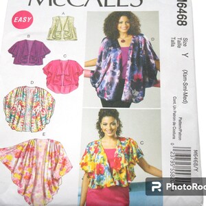 May include: McCall's sewing pattern M6468 for easy-to-sew women's tops. The pattern features a vest and several draped, open-front designs. The image displays the finished garments in various floral and abstract prints. The word "EASY" is in a pink circle.