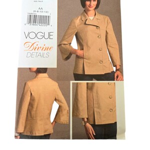 May include: Vogue Divine Details sewing pattern V8480. The pattern features a tan jacket with a notched collar, button closure, and three-quarter sleeves. The pattern includes multiple views of the jacket, with the size range AA (6-8-10-12).