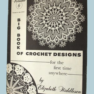 May include: A vintage crochet design book, "Big Book of Crochet Designs" by Elizabeth Hiddleson. The cover is black with white text and a large, detailed crochet pattern. The book is Volume 6, printed in the USA.