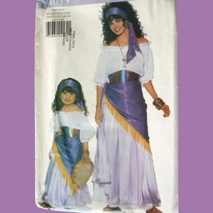 May include: A vintage Butterick sewing pattern, number 4653, featuring a woman and child in matching gypsy-style costumes. The costumes include white off-the-shoulder tops, long skirts, and headbands. The pattern's packaging is on a purple background.