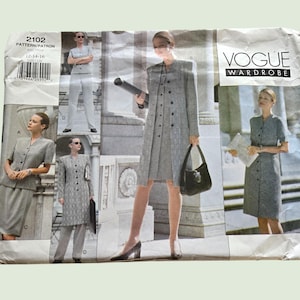 May include: Vogue Wardrobe sewing pattern showing women's suit and dress designs. The pattern includes images of a skirt suit, trouser suit, and a button-down dress, all in a grey textured fabric. The pattern number is 2102.