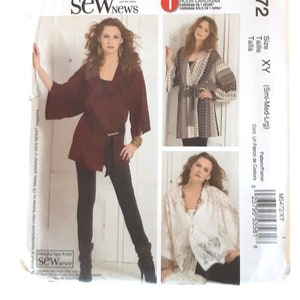 May include: A McCall's M5472 sewing pattern envelope for a 1 hour cardigan in sizes Sml-Med-Lrg. The front features three photographs of the finished garment in solid maroon, a patterned grey and white, and a white lace fabric with a tie waist.