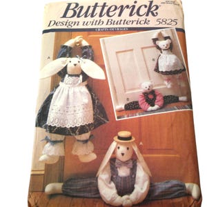 Op de afbeelding: Een vintage naaipatroon voor het maken van konijnen deurstoppers. Het patroon is van Butterick en het patroonnummer is 5825. Het patroon toont drie verschillende konijnen deurstopperontwerpen, een met een jurk, een met een overall en een met een hoed.