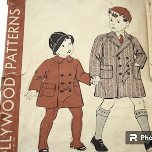 May include: Vintage sewing pattern cover featuring illustrations of two children in coats and hats. One child wears a double-breasted red coat and matching pants. The other child wears a herringbone coat, a red tie, and a cap. The cover reads "HOLLYWOOD PATTERNS".