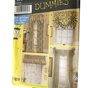 May include: Simplicity Sewing Patterns for Dummies window treatment pattern guide featuring four different window treatment designs. The pattern guide has a yellow background with the text "Simplicity Sewing Patterns for Dummies" in black and white. The guide displays four different window treatments, including a valance, a swag, and a set of curtains. The guide also provides instructions on how to sew the different window treatments.