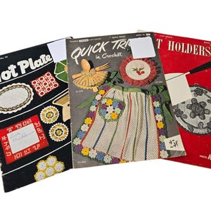 May include: Three vintage crochet pattern books with red, black, and white covers. The titles are "Hot Plate", "Quick Tricks in Crochet", and "T Holders".