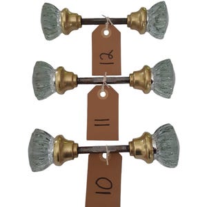 May include: Three sets of antique glass door knobs with brass accents. Each set is labeled with a price tag: 10, 11, and 12.