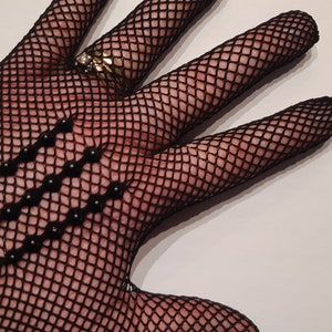 May include: Black fishnet gloves with black bead embellishments.