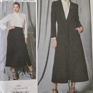 May include: A sewing pattern by Paco Peralta, Barcelona. The pattern features a long, dark gray coat with a notched collar and a matching skirt. The pattern also includes a white blouse. The pattern size is AX5 (4-6-8-10-12).