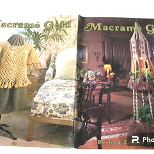May include: An open book titled "Macramé Gold" featuring a crocheted top with fringe on a dress form. The book also shows a macramé structure and interior design elements. The cover has a vintage aesthetic.
