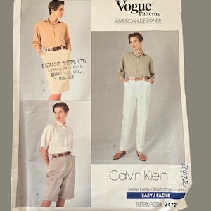 May include: A vintage Vogue Patterns sewing pattern featuring Calvin Klein designs. The pattern includes images of a model wearing a collared shirt with shorts, a skirt, and pants. The pattern is labeled "EASY / FACILE" and "PATTERN/PATRON 2472."
