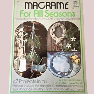 Peut inclure: Une couverture de livre vintage intitulée "MACRAME For All Seasons" avec des images de projets de macramé. La couverture présente une bordure et du texte verts, dont "47 projets au total". Les projets comprennent des porte-pots, des tentures murales, des bijoux et des sacs à main.