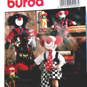May include: A Burda sewing pattern envelope for 3 differently sized clown dolls, labelled 4228. The package displays three dolls in various outfits, with indicated heights of 65 cm, 35 cm, and 20 cm, featuring a barcode and text.