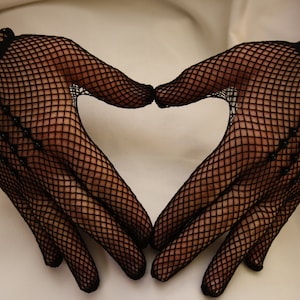 May include: A pair of black fishnet gloves forming a heart shape.