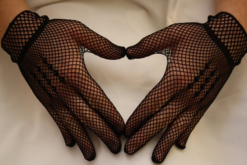 May include: A pair of black fishnet gloves forming a heart shape.