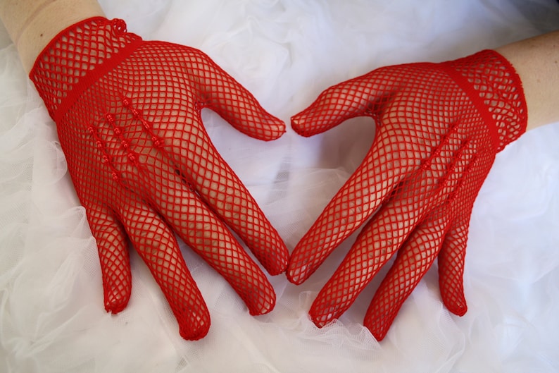 May include: A pair of red fishnet gloves with a heart shape formed by the hands.