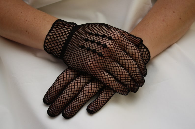 May include: A pair of black fishnet gloves with a diamond pattern.