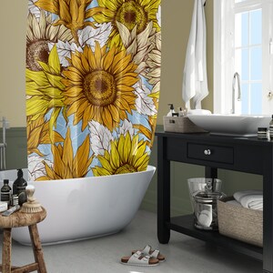 Puede incluir: Cortina de ducha con un dise&ntilde;o de girasoles amarillos, marrones y blancos. Est&aacute; en un ba&ntilde;o con una ba&ntilde;era blanca, un tocador negro y una ventana. La habitaci&oacute;n tiene un dise&ntilde;o moderno.