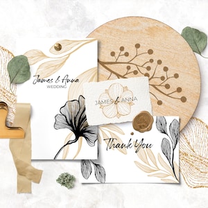 Pode incluir: Dois cart&otilde;es de convite de casamento com desenhos florais dourados e pretos. Os cart&otilde;es est&atilde;o sobre um fundo branco com um design de brilho dourado e um descanso de copo de madeira com um design floral dourado.