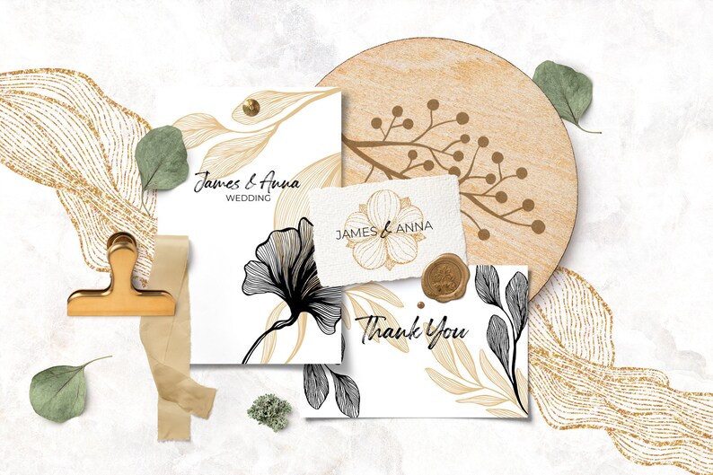 Pode incluir: Dois cart&otilde;es de convite de casamento com desenhos florais dourados e pretos. Os cart&otilde;es est&atilde;o sobre um fundo branco com um design de brilho dourado e um descanso de copo de madeira com um design floral dourado.