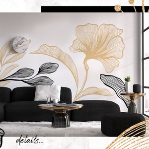 Pode incluir: Um design de interior de sala de estar com um sof&aacute; preto, uma mesa de caf&eacute; preta e dourada e um otomano preto. A parede apresenta um design floral em grande escala em ouro e preto.