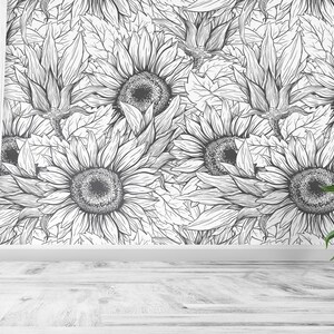 Puede incluir: Papel pintado de girasoles en blanco y negro con un dise&ntilde;o floral detallado. Una cortina blanca cuelga a la izquierda. Dos peque&ntilde;os girasoles en macetas con p&eacute;talos amarillos y macetas marrones est&aacute;n a la derecha.