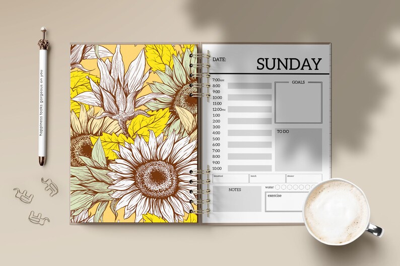 Puede incluir: Agenda abierta con un dise&ntilde;o de girasoles en la p&aacute;gina izquierda y un horario del domingo en la derecha. Incluye un bol&iacute;grafo con el texto "happiness looks gorgeous on you" y una taza de caf&eacute;.
