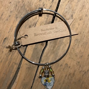 Adjustable steel bangle with Vintage tin charm