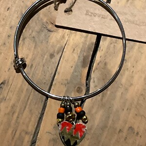 Adjustable steel bangle with Vintage tin charm
